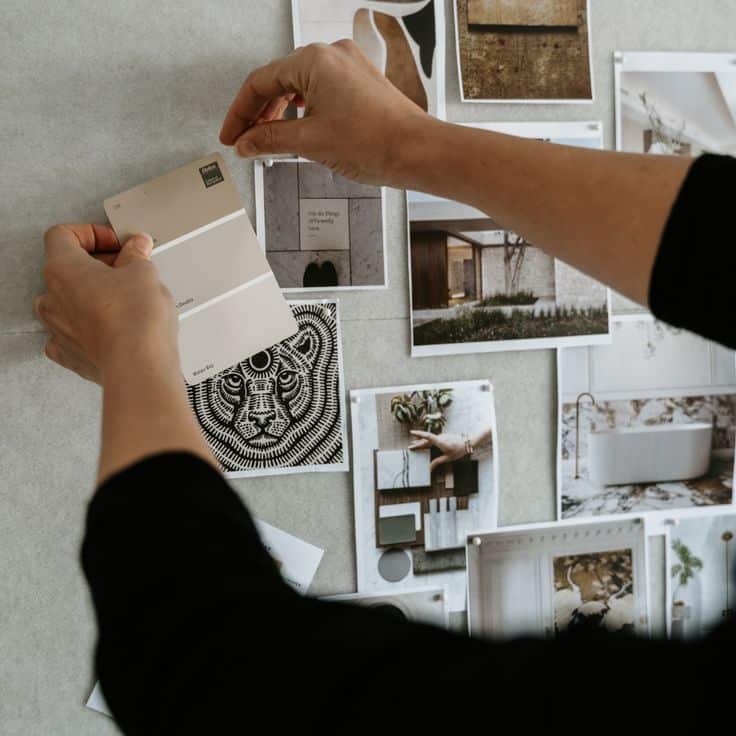 DESIGNER FOR A DAY _ ADLibrary Person arranging color swatches and photos on a vision board for interior design inspiration. | Sky Rye Design Person arranging color swatches and photos on a vision board for interior design inspiration.