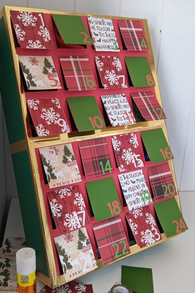 DIY Advent Calendar for Kids_ 3+ Kids DIY festive advent calendar with numbered red and green pockets, decorated with holiday motifs. | Sky Rye Design DIY festive advent calendar with numbered red and green pockets, decorated with holiday motifs.