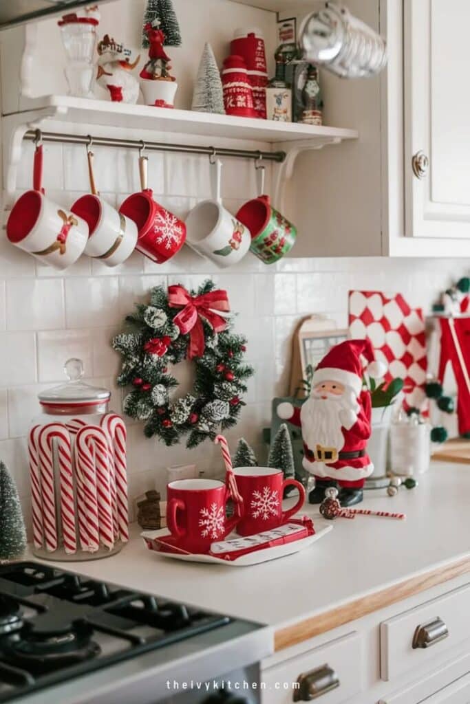 Festive kitchen decor with red mugs, candy canes, Santa figure, and wreath. Holiday cheer and Christmas spirit.