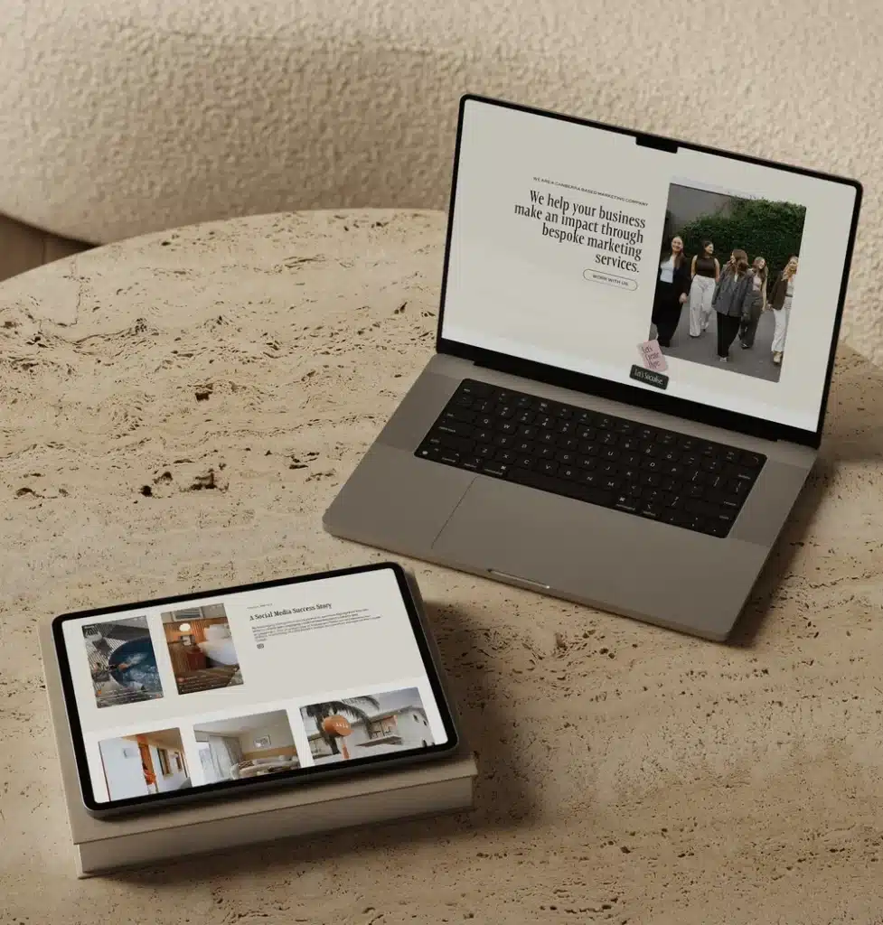 Laptop and tablet on a stone table displaying marketing services and media success stories.