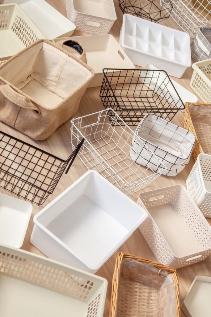 Assorted storage baskets of various materials and designs on a wooden floor. Ideal for home organization solutions.