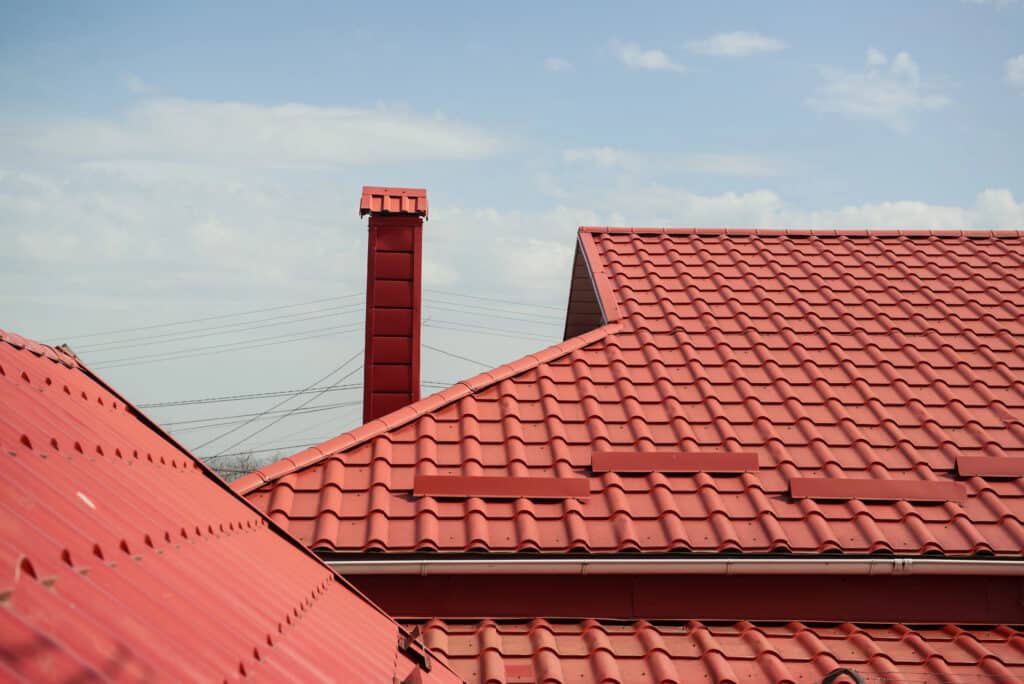 Depositphotos_542500954_XL Red tile roof with chimney under a clear sky, showcasing durable and stylish roofing solutions. | Sky Rye Design Red tile roof with chimney under a clear sky, showcasing durable and stylish roofing solutions.