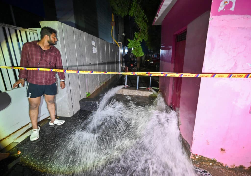 Three UPSC Aspirants Die After Caching Centres Basement Gets Flooded In Rajinder Nagar Students Protest Flooded urban alley with police tape and observing person at night. | Sky Rye Design Flooded urban alley with police tape and observing person at night.