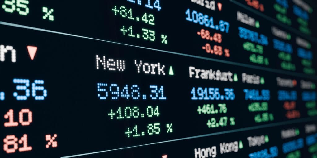 Depositphotos_791643156_XL Stock market display showing indices from New York and Frankfurt, with percentage gains in green and losses in red. | Sky Rye Design Stock market display showing indices from New York and Frankfurt, with percentage gains in green and losses in red.