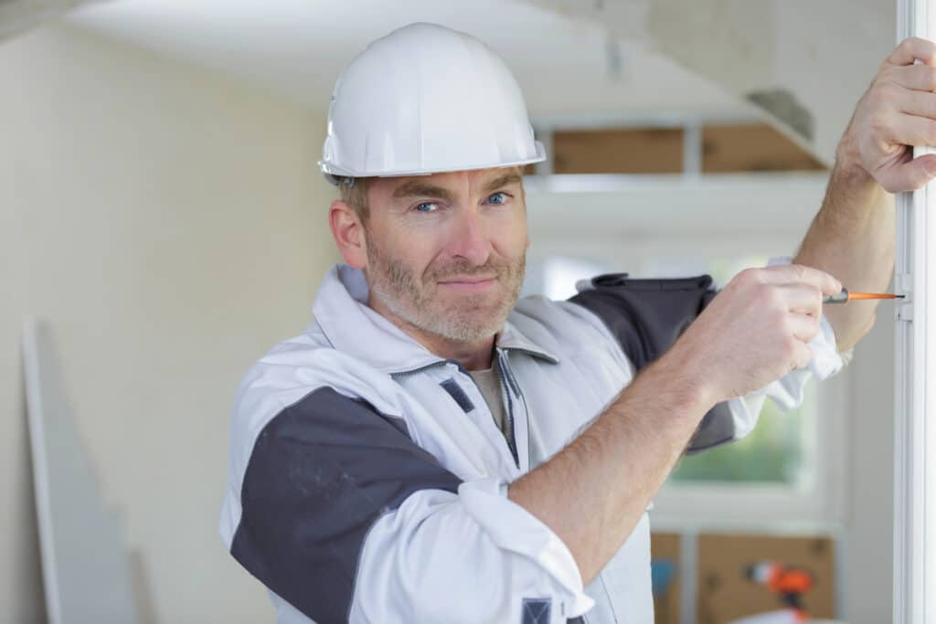 Depositphotos_836143262_XL Construction worker using screwdriver indoors, wearing a safety helmet and uniform. | Sky Rye Design Construction worker using screwdriver indoors, wearing a safety helmet and uniform.