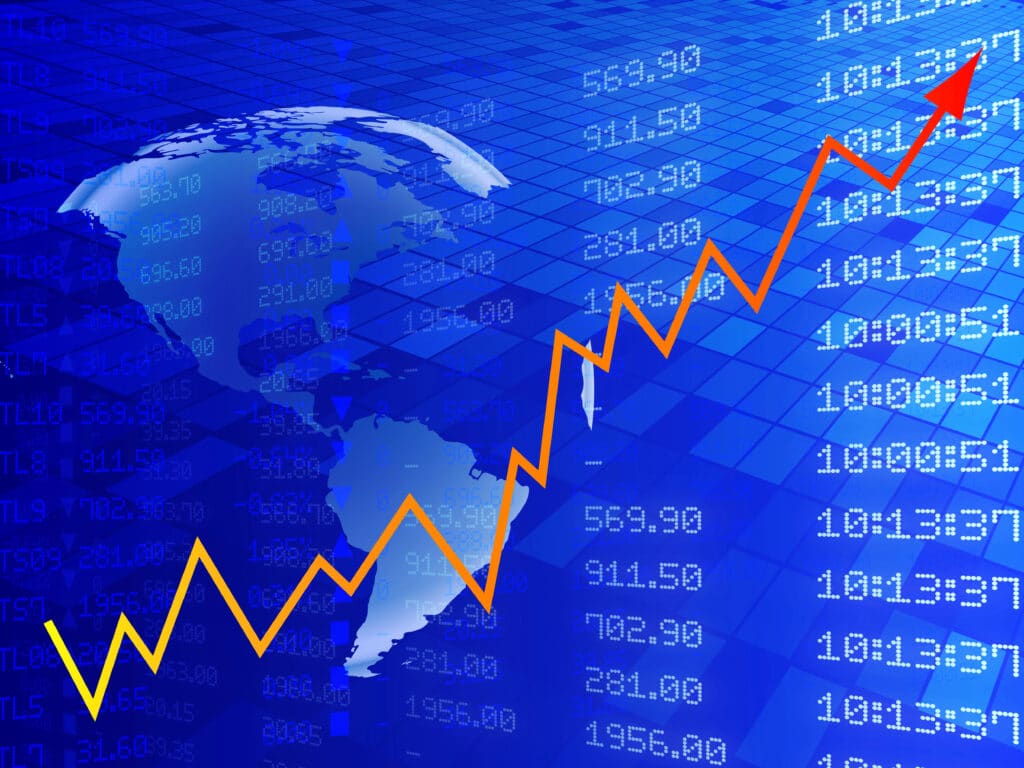 Rising stock market graph over a digital world map background indicating global financial growth.