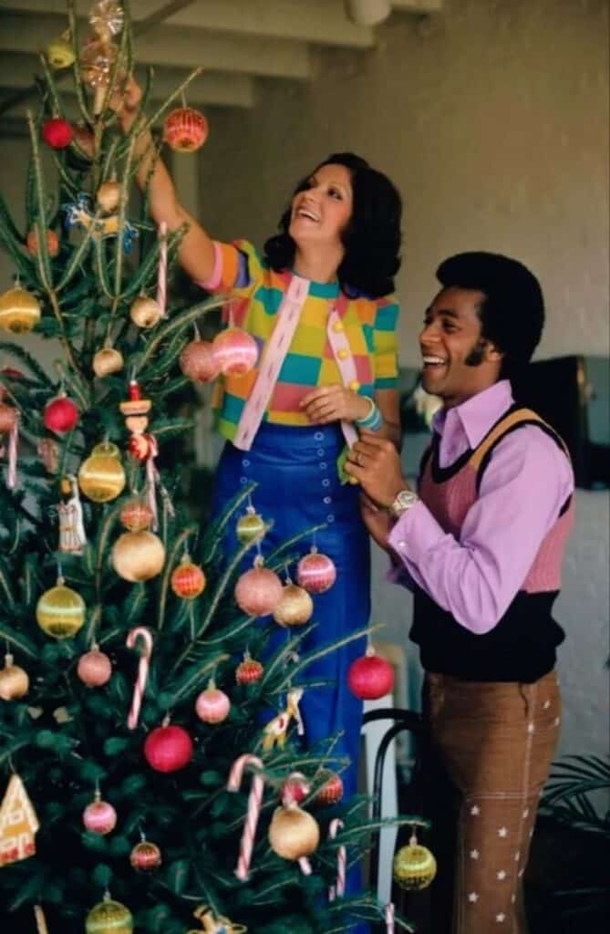 People decorating a Christmas tree with colorful ornaments and candy canes, celebrating the festive holiday season.
