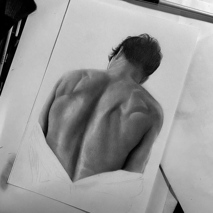 Realistic pencil drawing of a man's muscular back, partially covered with a shirt, showing detailed shading.