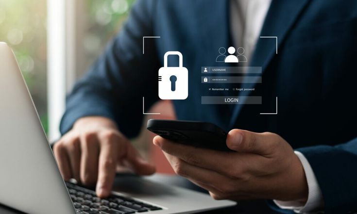 Person using a smartphone and laptop with digital security login interface overlay.