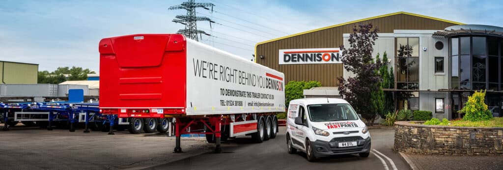 Trailer parked outside Dennison facility with branded van and building, showcasing logistics services.