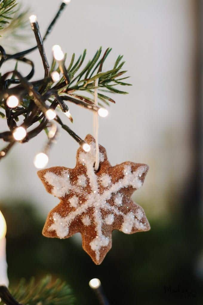 Gingerbread Salt Dough Ornaments Gingerbread snowflake ornament on a Christmas tree with twinkling lights and pine needles. | Sky Rye Design Gingerbread snowflake ornament on a Christmas tree with twinkling lights and pine needles.