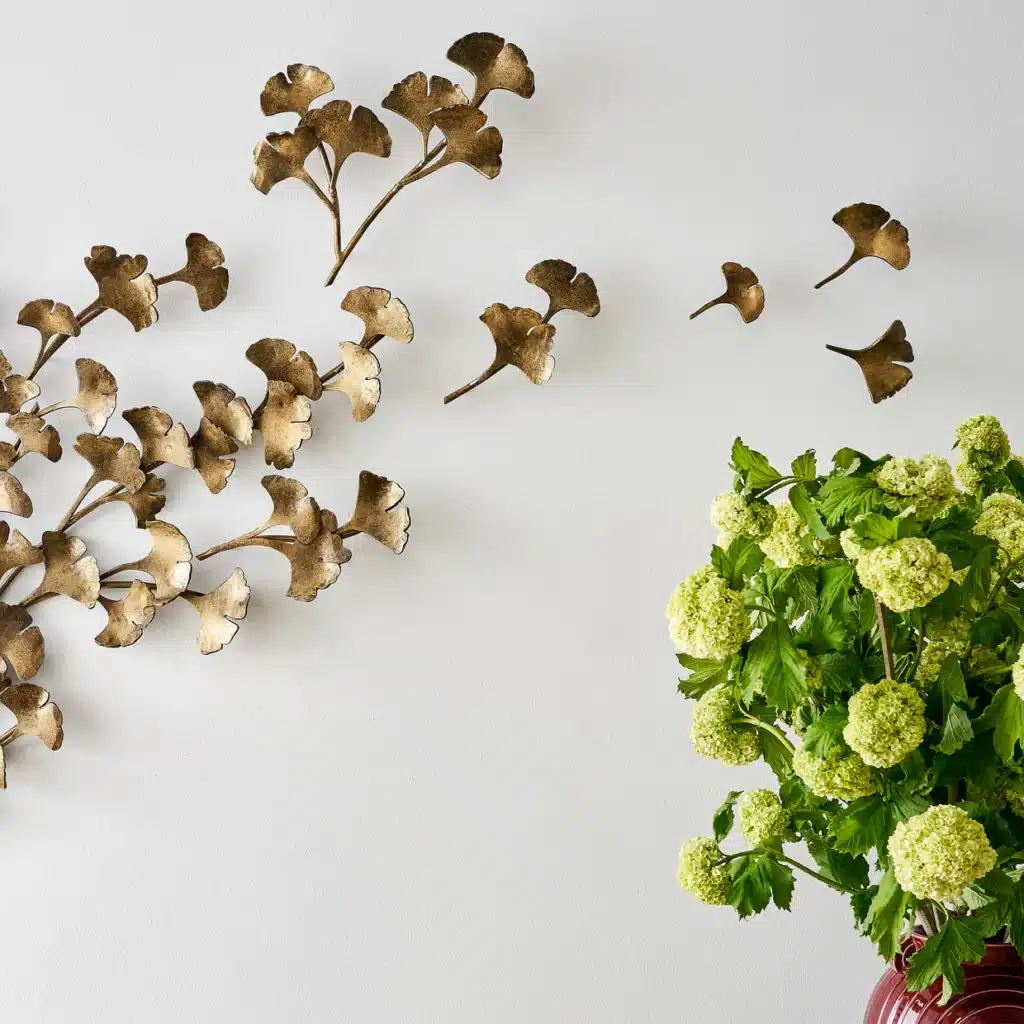 GinkgoWallSculpture_ClaireCroweCollection-detail-web Metallic ginkgo wall art with green viburnum flowers in a red vase on a white wall background. | Sky Rye Design Metallic ginkgo wall art with green viburnum flowers in a red vase on a white wall background.