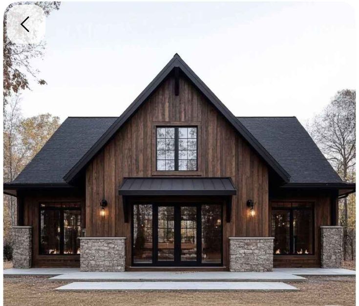Google Search Modern rustic cabin with wooden exterior, large windows, and pitched roof in a serene forest setting. | Sky Rye Design Modern rustic cabin with wooden exterior, large windows, and pitched roof in a serene forest setting.