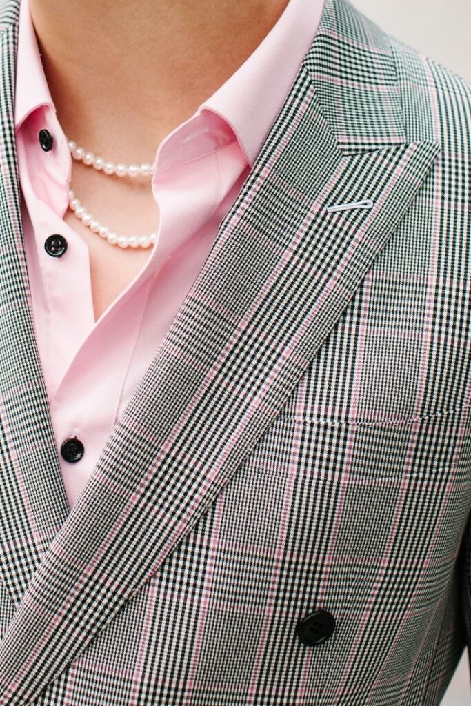 Grey Pink Glen Plaid Double Breasted Suit - Tailor Cooperative Close-up of plaid blazer with pink shirt and pearl necklace for a stylish, modern fashion look. | Sky Rye Design Close-up of plaid blazer with pink shirt and pearl necklace for a stylish, modern fashion look.