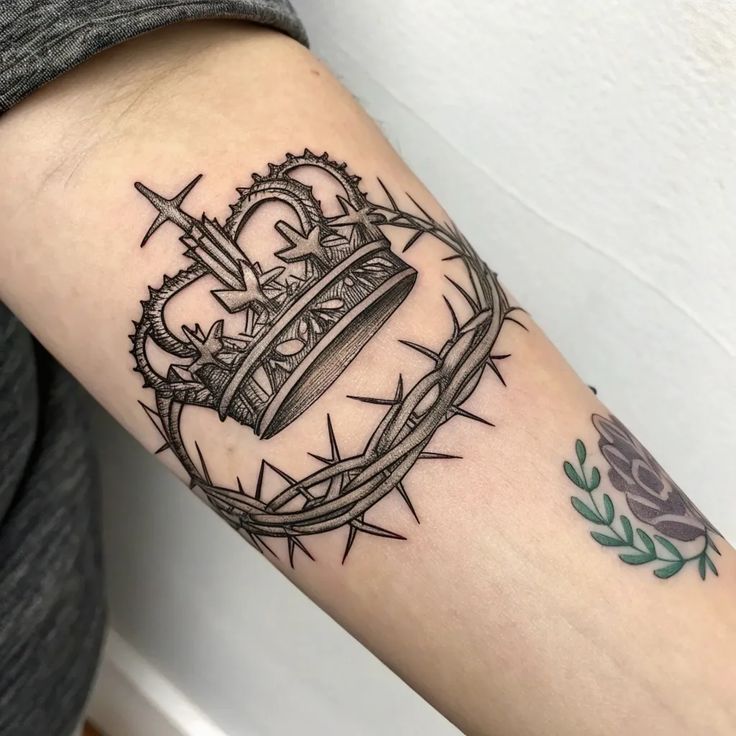 Harmonious - Crown of Thorns Tattoo Symbolism and Hidden Meanings Tattoo of a detailed crown and thorns on an arm, symbolizing royalty and sacrifice. | Sky Rye Design Tattoo of a detailed crown and thorns on an arm, symbolizing royalty and sacrifice.