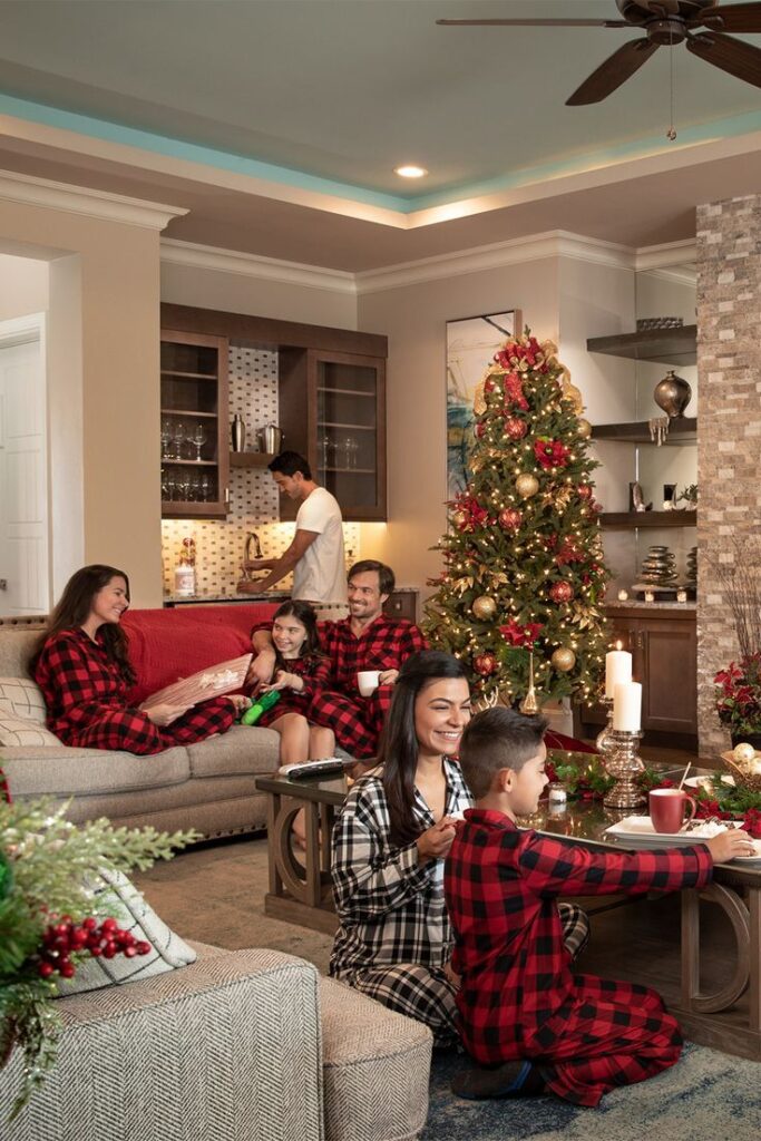 Holiday Vacation Homes in Kissimmee Worth Booking Family in matching pajamas enjoying Christmas in a cozy living room with decorated tree and holiday lights. | Sky Rye Design Family in matching pajamas enjoying Christmas in a cozy living room with decorated tree and holiday lights.