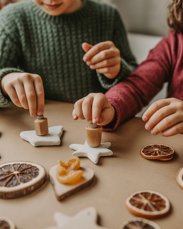 Homemade Ornaments with Kids Children crafting with star-shaped clay and dried oranges on a table. | Sky Rye Design Children crafting with star-shaped clay and dried oranges on a table.