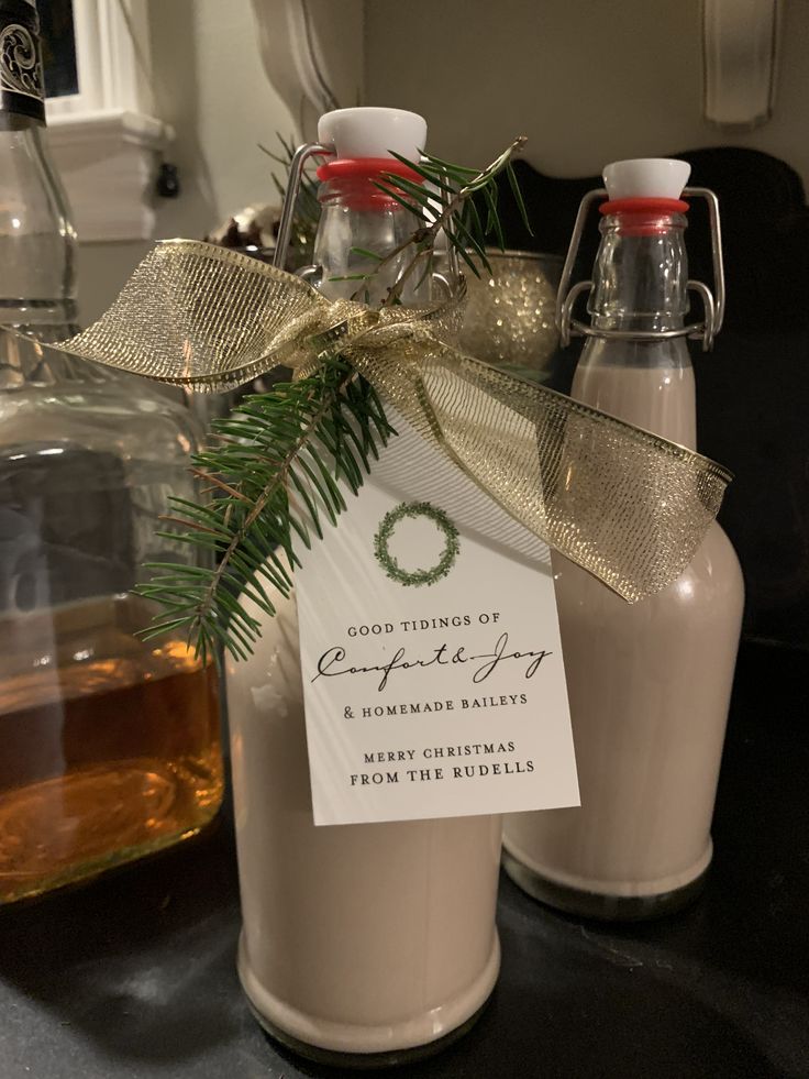 Hostess Gift Ideas - Homemade Baileys for Christmas - Holiday Gift Ideas Homemade Baileys bottle with festive decor and gift tag, gold ribbon and pine sprig for Christmas celebration. | Sky Rye Design Homemade Baileys bottle with festive decor and gift tag, gold ribbon and pine sprig for Christmas celebration.