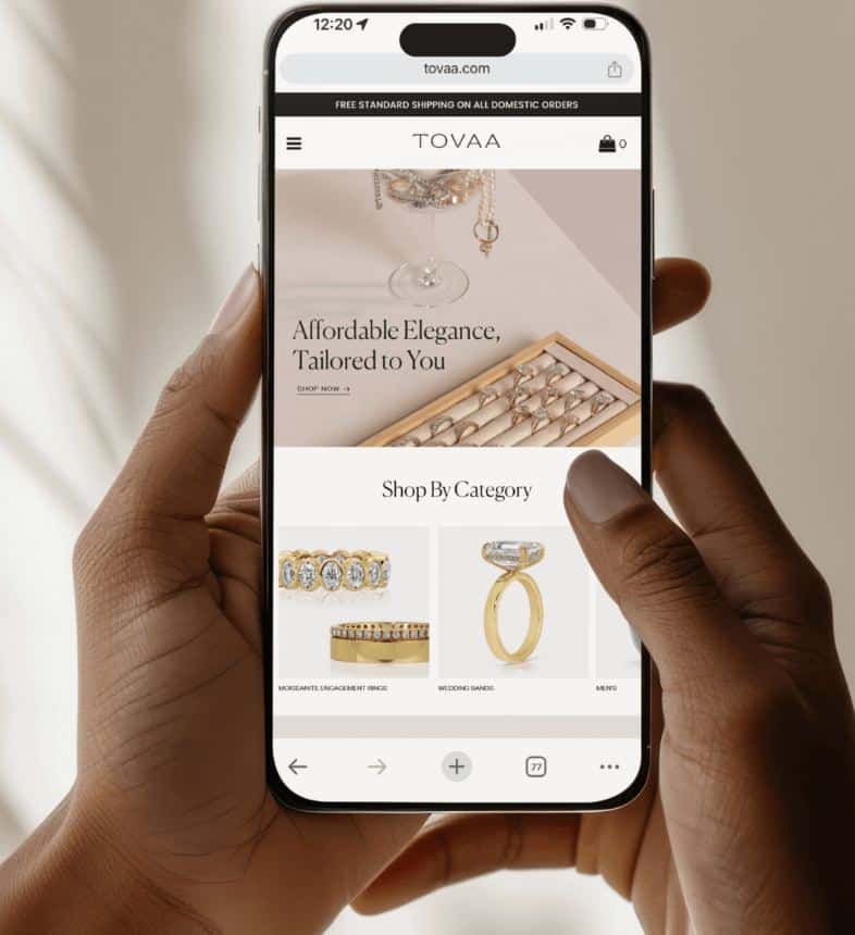 Person browsing Tovaa jewelry website on a smartphone, showcasing elegant rings and accessories for purchase.