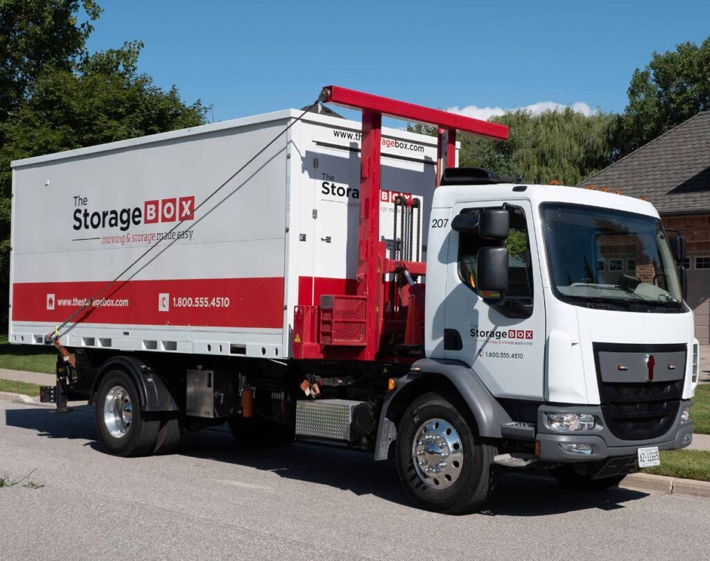 IMAGE 2025-10-21 112550 Red and white storage box truck parked on a sunny day, offering moving and storage services. | Sky Rye Design Red and white storage box truck parked on a sunny day, offering moving and storage services.