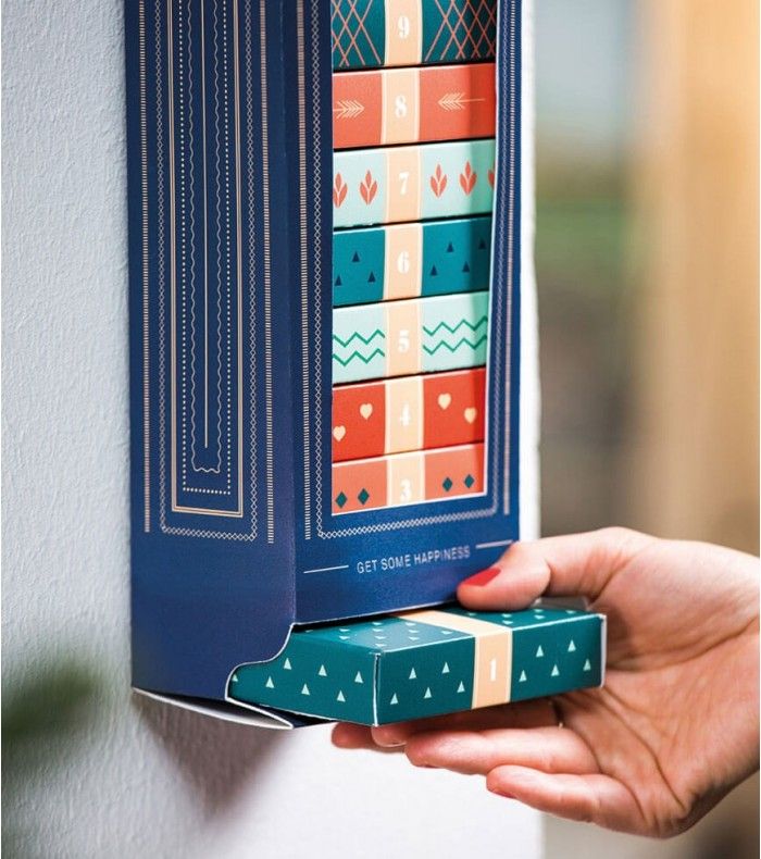 Idée cadeau créatif DIY à faire soi-même + 156 idées Person opening a colorful, numbered wall calendar box labeled Get Some Happiness, revealing surprise compartments. | Sky Rye Design Person opening a colorful, numbered wall calendar box labeled Get Some Happiness, revealing surprise compartments.