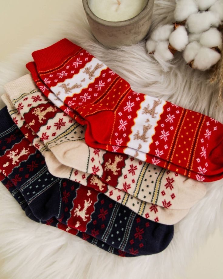 If your socks dont look like this by now youre Festive holiday socks with reindeer and snowflake designs arranged on a fur surface near a lit candle. | Sky Rye Design Festive holiday socks with reindeer and snowflake designs arranged on a fur surface near a lit candle.