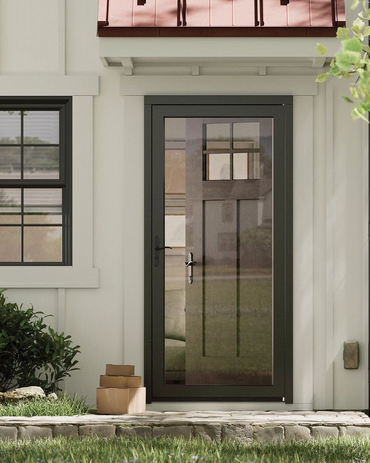 Integrated Storm and Entry Door Modern front door with glass panes and packages on porch, framed by white siding and black trim. | Sky Rye Design Modern front door with glass panes and packages on porch, framed by white siding and black trim.