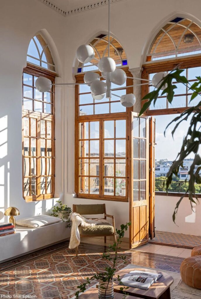 Jaffa House - Fineshmaker Bright sunlit room with arched windows, modern furniture, and pendant lighting. Cozy reading nook by the window. | Sky Rye Design Bright sunlit room with arched windows, modern furniture, and pendant lighting. Cozy reading nook by the window.
