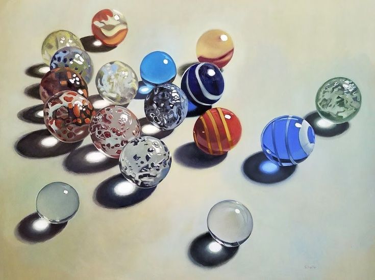 Colorful marbles on a light surface with shadows, showcasing a variety of patterns and reflections.