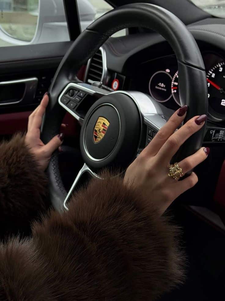 Lady mafia 💓🌺 Close-up of hands on Porsche steering wheel, wearing fur coat and ring, luxury driving experience. | Sky Rye Design Close-up of hands on Porsche steering wheel, wearing fur coat and ring, luxury driving experience.