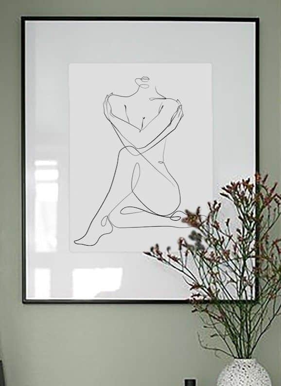 Line drawing woman minimalist wall art print_ Minimalist line art of a seated nude figure in a frame, beside a vase with flowers on a green wall. | Sky Rye Design Minimalist line art of a seated nude figure in a frame, beside a vase with flowers on a green wall.