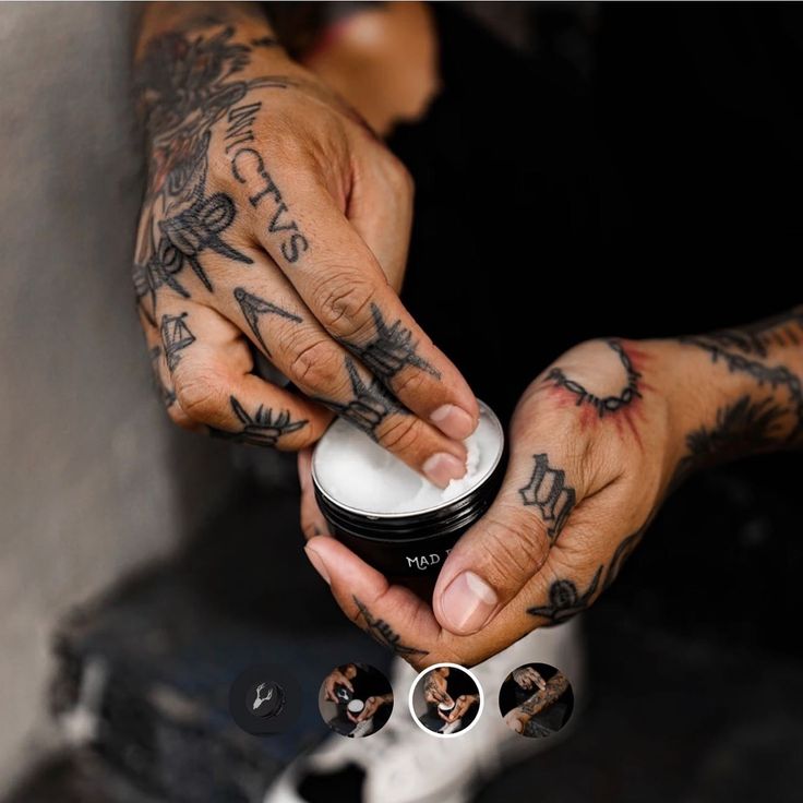 Tattooed hands applying cream from a small container, showcasing personal care and skincare routine.