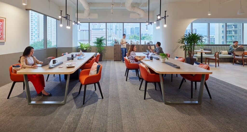 Mask-Group-137_CentralPlaza Modern coworking space with people working at shared desks, laptops, and plants, creating a collaborative atmosphere. | Sky Rye Design Modern coworking space with people working at shared desks, laptops, and plants, creating a collaborative atmosphere.