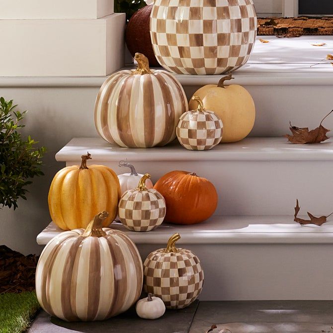 Decorative checkered and striped pumpkins on porch steps, adding a festive autumn touch.
