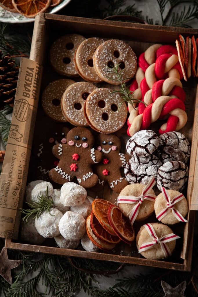 Assorted festive cookies in a wooden tray, including gingerbread, crinkle, and snowball cookies. Perfect for holidays.