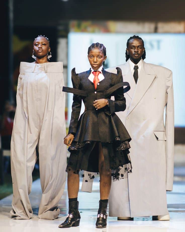 Models wearing oversized, avant-garde fashion on a runway, featuring bold, structured designs.