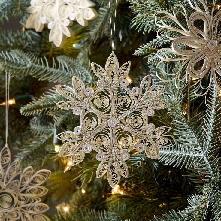 Paper Quilling Snowflake Ornaments Set of 9 Handcrafted quilled snowflake ornament hanging on a Christmas tree with fairy lights. | Sky Rye Design Handcrafted quilled snowflake ornament hanging on a Christmas tree with fairy lights.