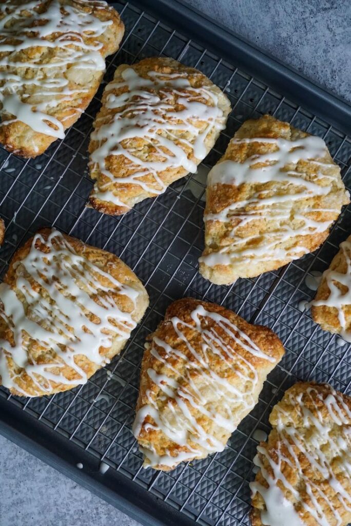 Pear Ginger Scone Freshly baked scones with white icing drizzled on top, cooling on a wire rack. | Sky Rye Design Freshly baked scones with white icing drizzled on top, cooling on a wire rack.
