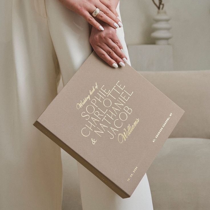 Photo Wedding Family Album Latte+ Real Gold Lettering Handmade 4x6 5x7 for 80-200 photos Personalized lettering Scrapbooking Elegant hand holding a personalized wedding book with golden text. | Sky Rye Design Elegant hand holding a personalized wedding book with golden text.