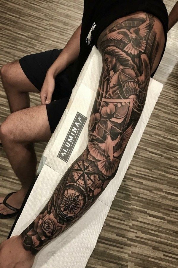 Intricate full-sleeve tattoo with doves, compass, and knight design, showcasing detailed black and white artistry.