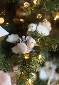 Pinecone Bird Ornament Handmade bird ornaments on a Christmas tree with lights and pinecone details enhance holiday decoration ambiance. | Sky Rye Design Handmade bird ornaments on a Christmas tree with lights and pinecone details enhance holiday decoration ambiance.