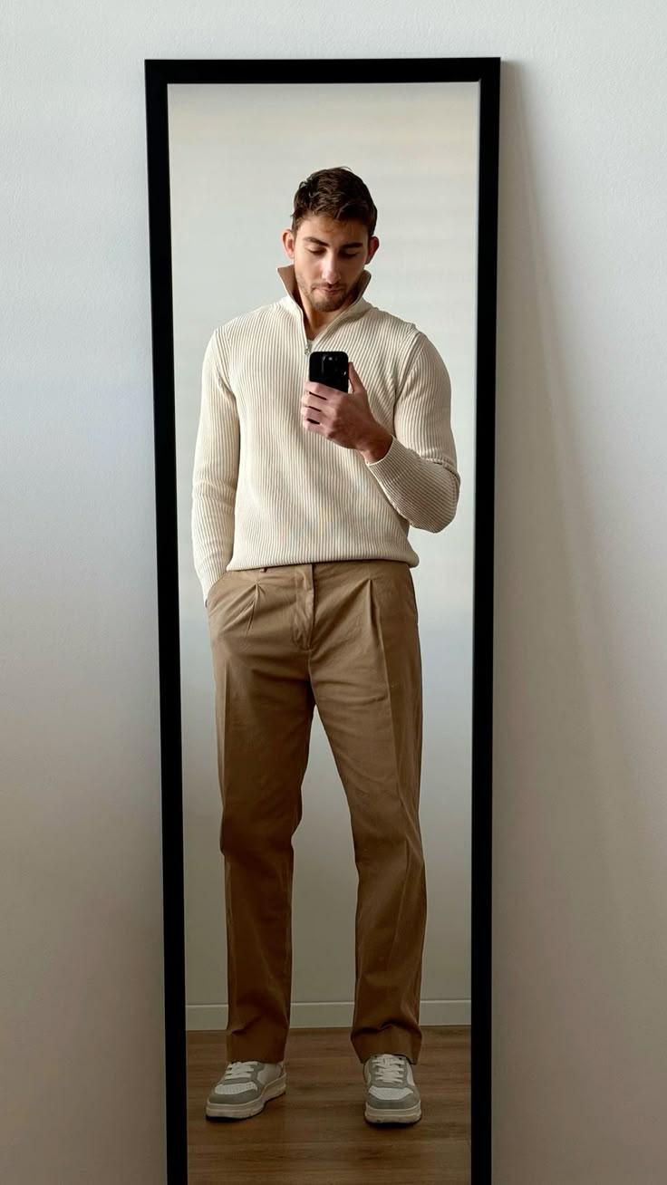 Quarter zip + loose pants outfit Man taking mirror selfie in stylish outfit: beige sweater, tan pants, and white sneakers. | Sky Rye Design Man taking mirror selfie in stylish outfit: beige sweater, tan pants, and white sneakers.