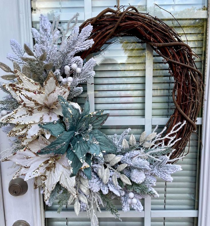 Snowy Poinsettia Grapevine Wreath_ Teal White Winter Decor Festive winter wreath with pinecones, glittery poinsettias, and frosted leaves on a rustic vine base, hanging on a door. | Sky Rye Design Festive winter wreath with pinecones, glittery poinsettias, and frosted leaves on a rustic vine base, hanging on a door.