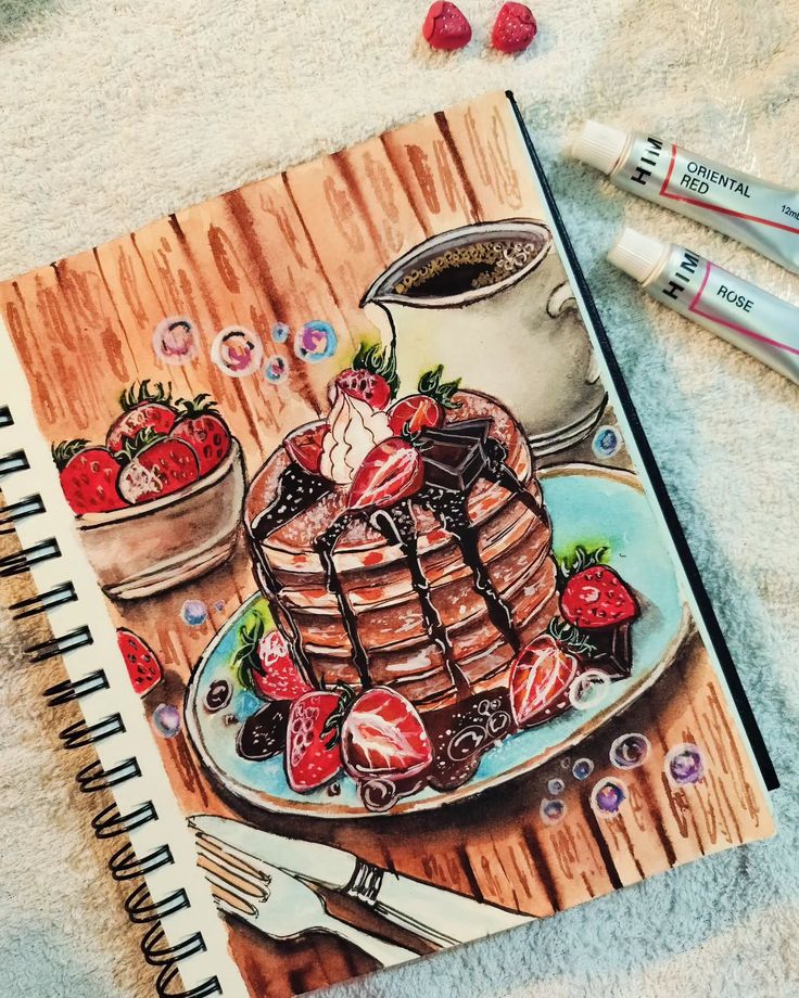 Illustration of pancakes with strawberries and chocolate, next to paint tubes and a cup of coffee on a wooden table.