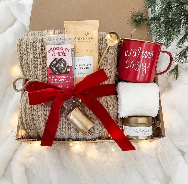 The Best Aesthetic and Girly Christmas Gift Ideas for 2024 Cozy holiday gift box with blanket, cocoa, mug, and treats, wrapped in a red bow, festive and warm presentation. | Sky Rye Design Cozy holiday gift box with blanket, cocoa, mug, and treats, wrapped in a red bow, festive and warm presentation.