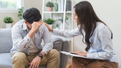 Therapist comforting a distressed man in an office setting, offering emotional support and counseling.