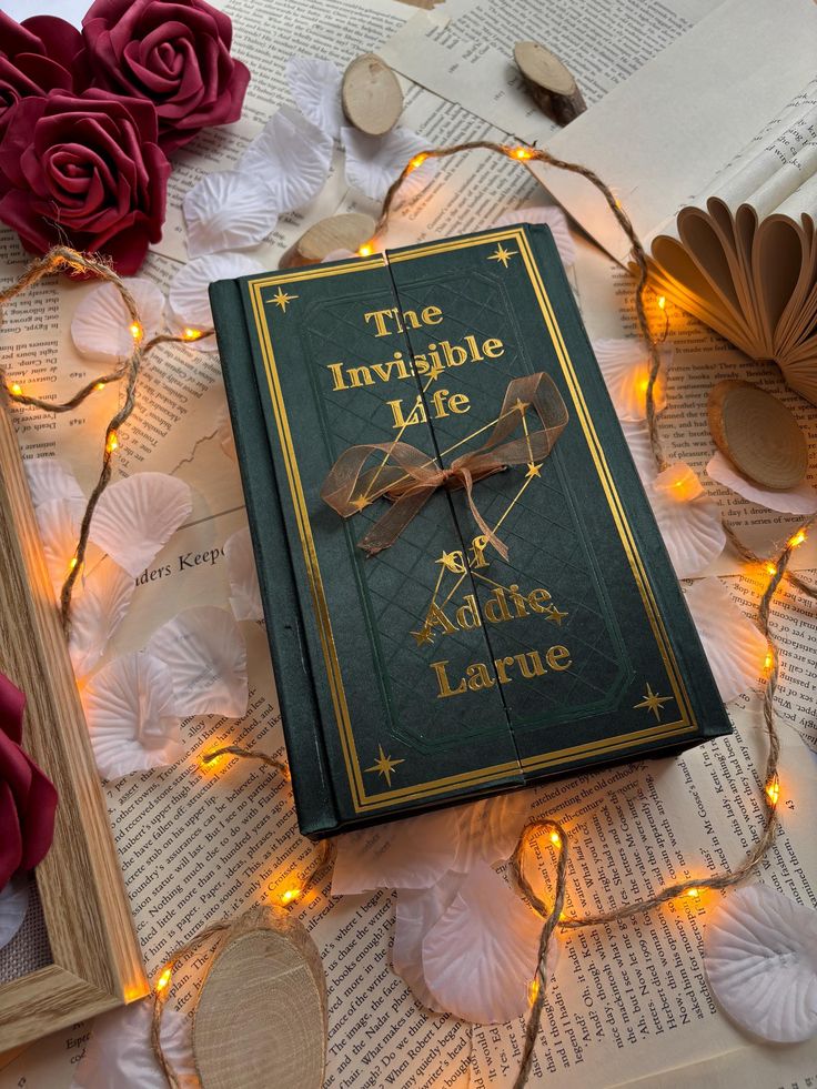 The Invisible Life of Addie LaRue -- Handbound Special Edition Rebind Book The Invisible Life of Addie LaRue on open pages, surrounded by roses and fairy lights. | Sky Rye Design Book The Invisible Life of Addie LaRue on open pages, surrounded by roses and fairy lights.