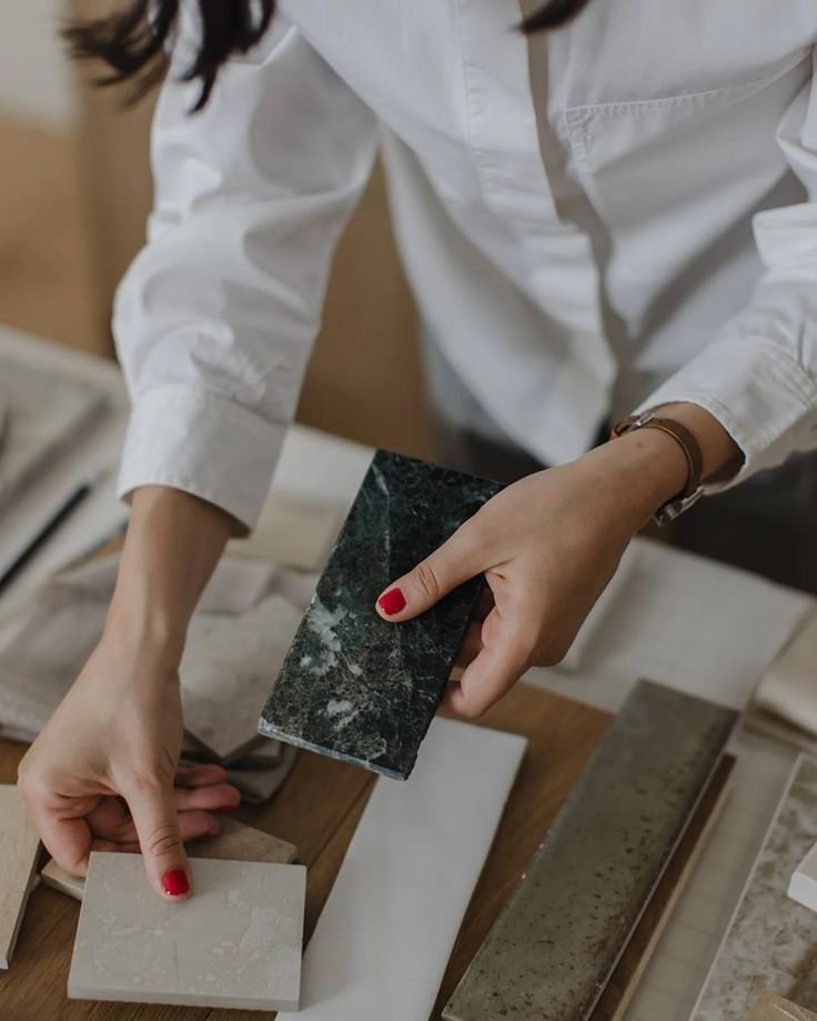 Person selecting countertop materials and tiles in a design studio.