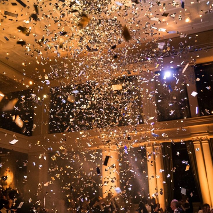 Top 10 New Years Wedding Reception Ideas for an Unforgettable Celebration Confetti shower in a grand ballroom with warm lighting, creating a festive celebration atmosphere. | Sky Rye Design Confetti shower in a grand ballroom with warm lighting, creating a festive celebration atmosphere.
