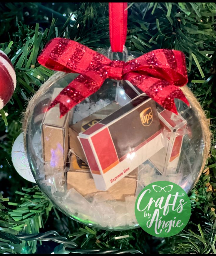 Christmas ornament with mini UPS boxes and red bow on green tree, labeled Crafts by Angie.